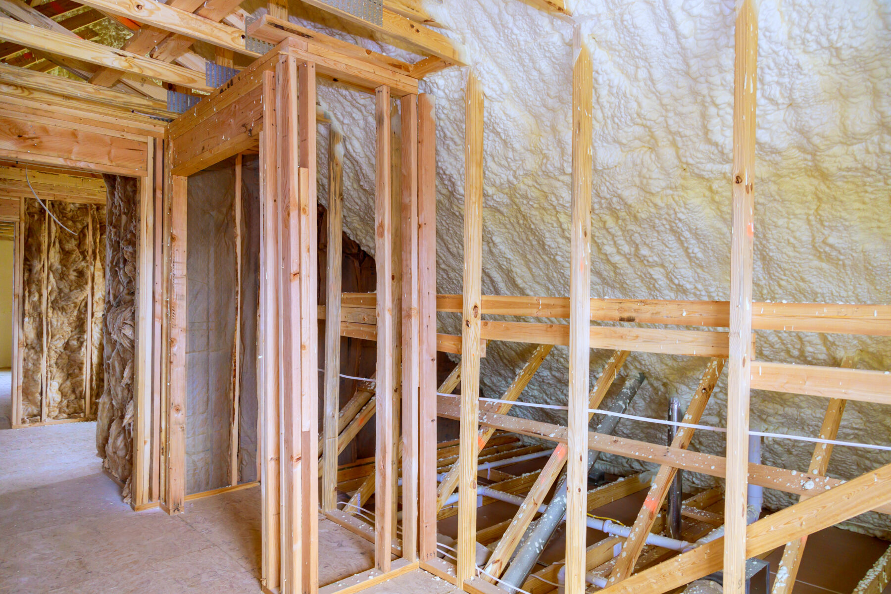 Under roof of new frame house, thermal foam insulation is installed for insulation purposes